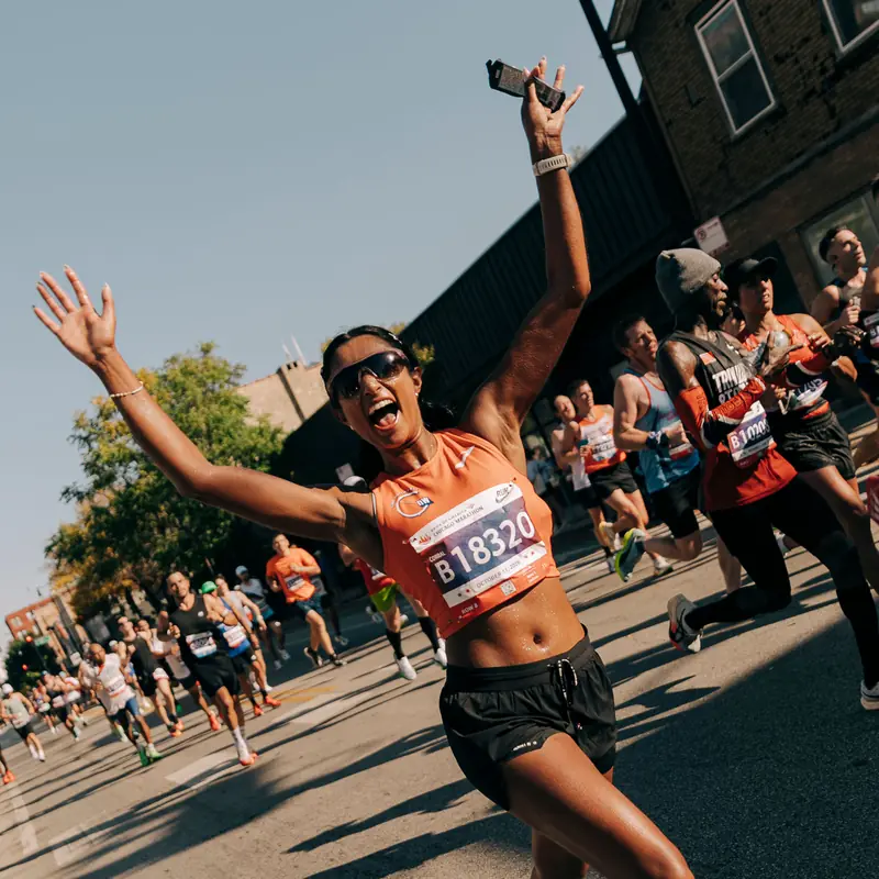 A runner with both arms up celebrating on race day