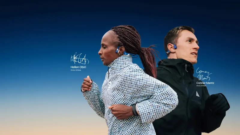 Two runners in open-ear headphones against a dusk sky