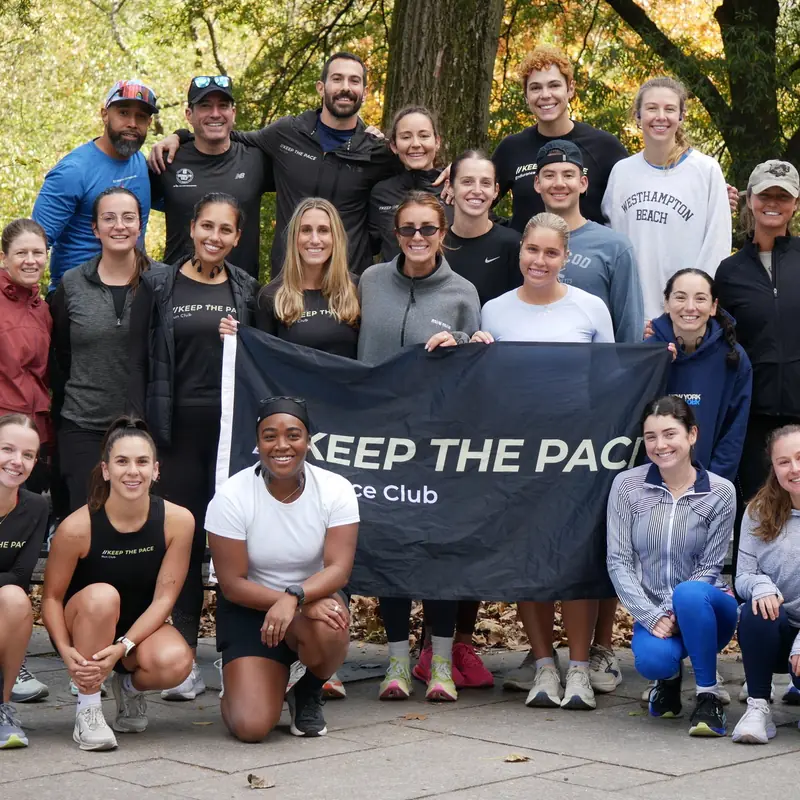 A run club posing with its banner among autumn trees