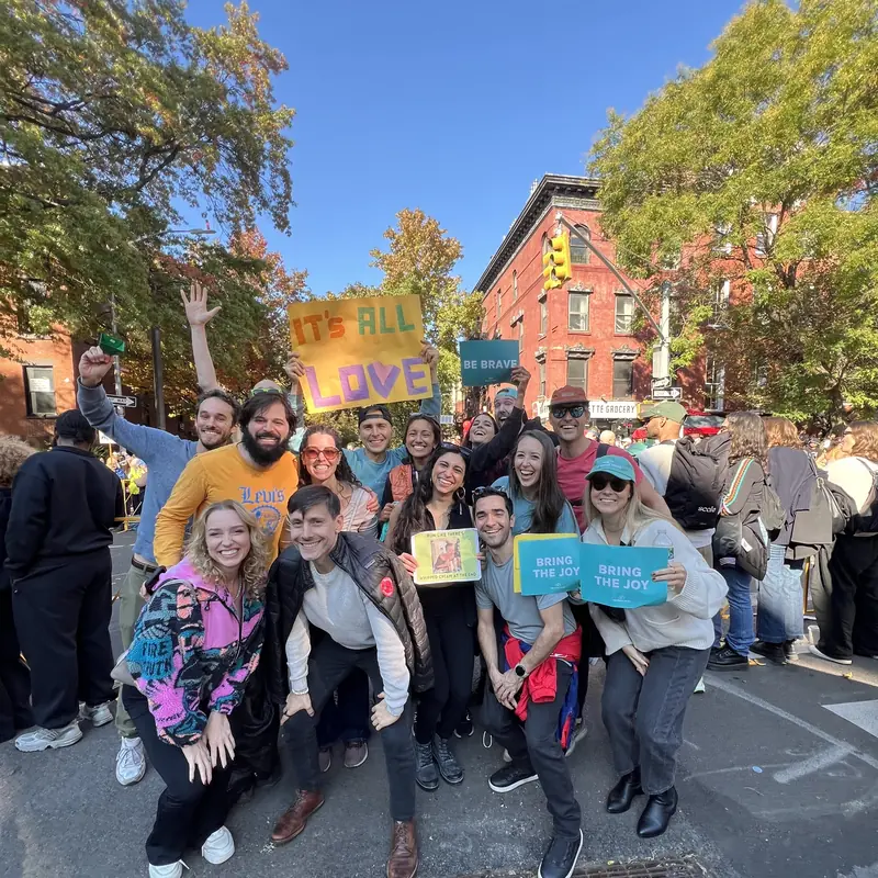Cheerers with Be Brave signs on a Brooklyn street corner