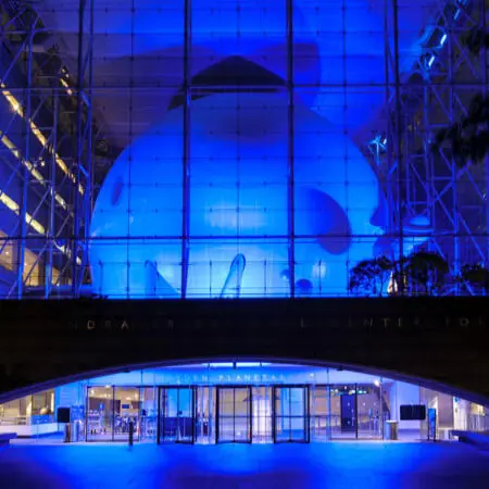 The museum's glass cube lit blue at night