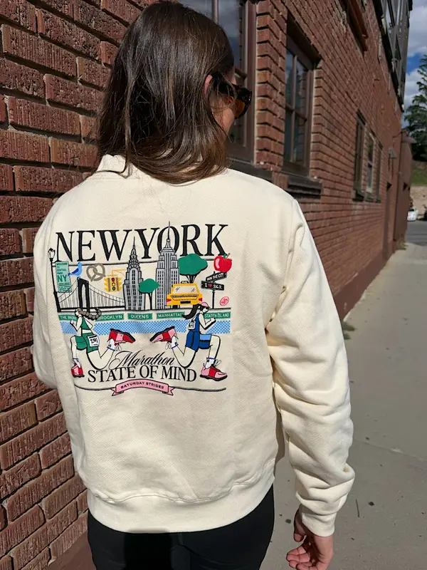 A runner seen from behind in a cream New York marathon sweatshirt