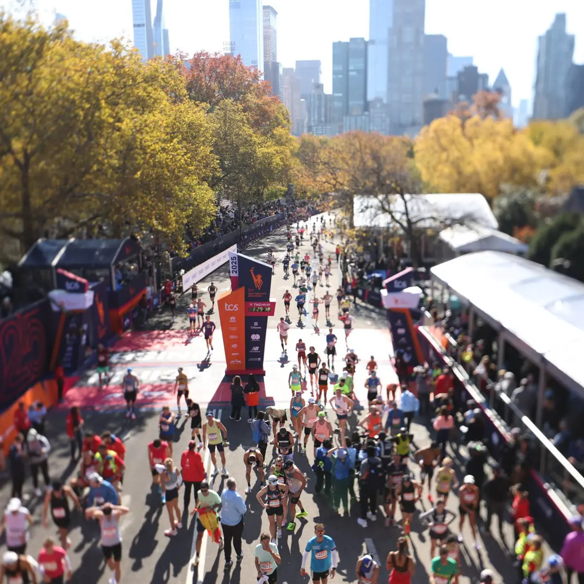 A marathon finish from above, with the crowds and the skyline behind