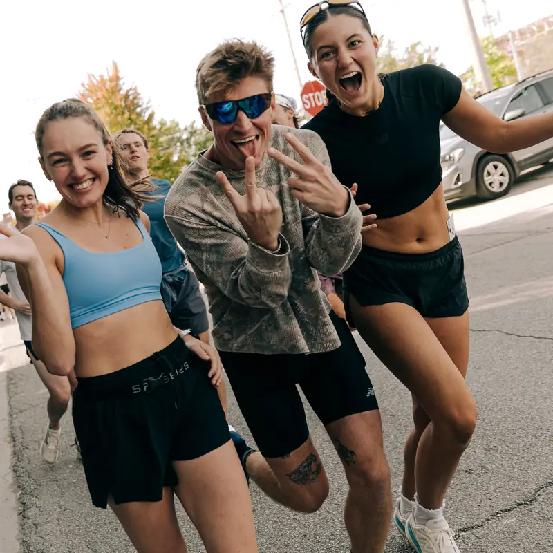 Three runners smiling at the camera on a group run