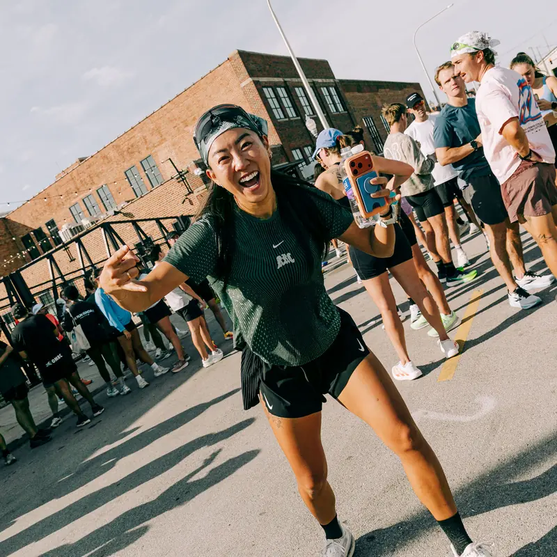 A runner laughing at the camera, the group run behind