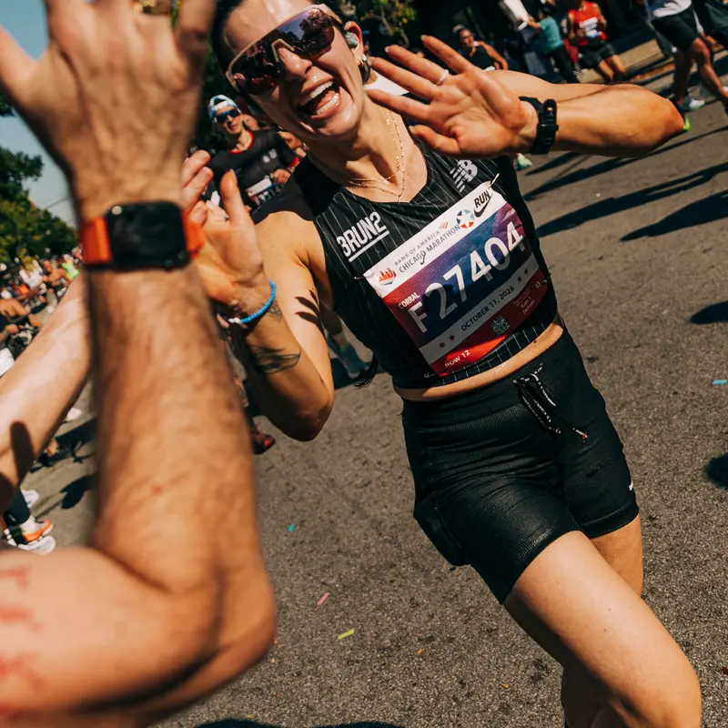 A runner high-fiving a spectator's hand mid-race