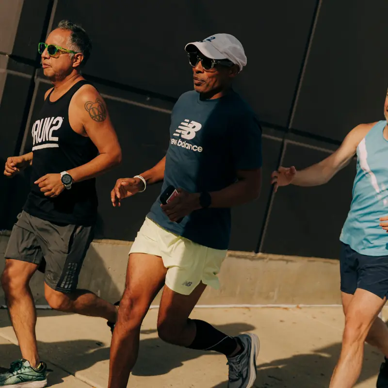 Two runners side by side on a sidewalk